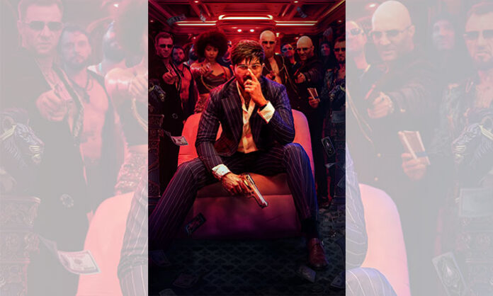 Dulquer Salmaan in the first look poster of I’M GAME movie holding a gun with blood-stained hands in a nightclub and casino backdrop