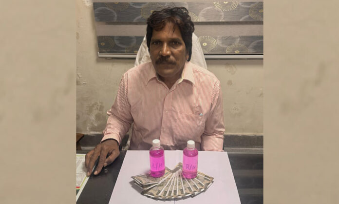 ACB officials arresting District Agriculture Officer Anjaneyulu Goud during a bribe trap in Wanaparthy district