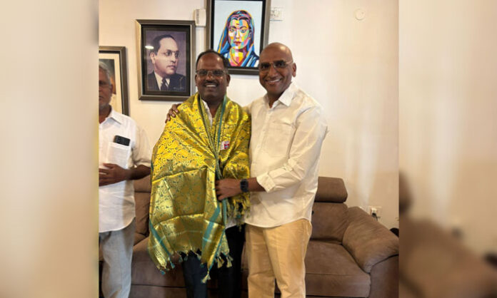 Dr R.S. Praveen Kumar IPS felicitating Bandaravirala Sarpanch Kandikanti Vijay Kumar at his residence