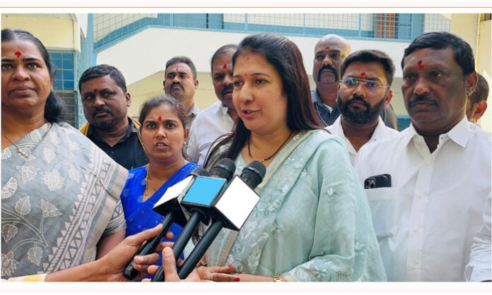 Kavya Reddy handing over examination fee support documents to government school students in Addagutta.