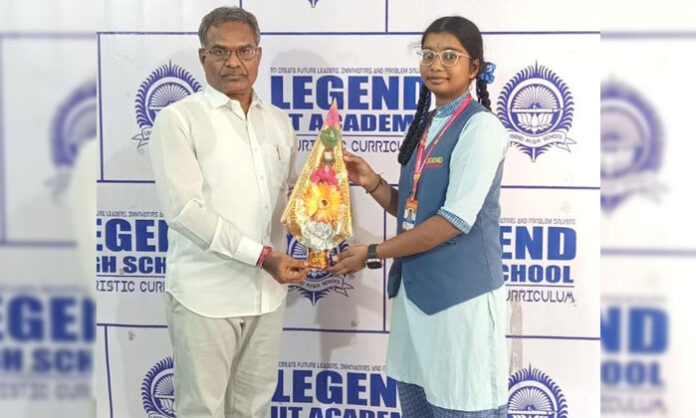 Legend High School student Shreshta Nandini being congratulated by correspondent Rajaiah for her selection in the state-level swimming competitions at a school program.