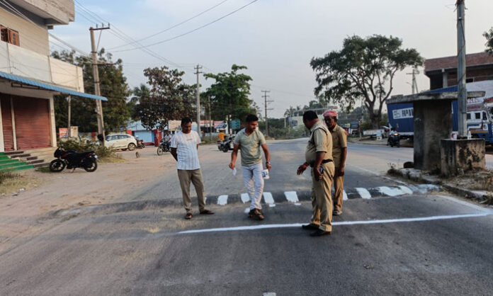 Police officers installing and painting speed breakers near Jagadevpur Police Station to prevent frequent road accidents.