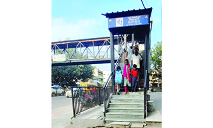 Tarnaka foot over bridge in Hyderabad stands unused due to a damaged lift, forcing students and elderly residents to cross the busy road dangerously.