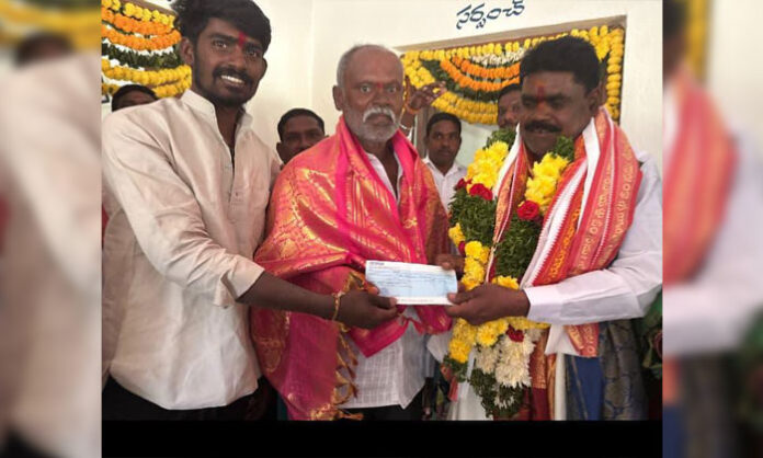 Vilasagar Sarpanch Enugula Kanakaiah handing over Rs.5000 cheque for birth of a baby girl