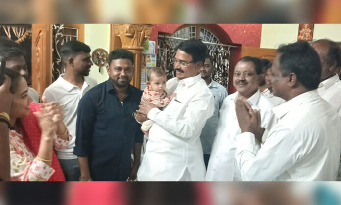 Former Minister Niranjan Reddy blessing a child during cradle ceremony and birthday celebration in Kothakota, Wanaparthy district