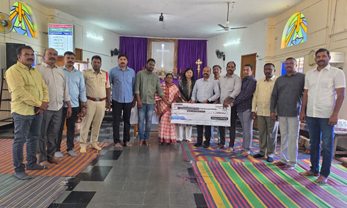Police officers handing over financial assistance cheque to family of late CI Johnson Babu