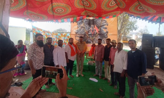 Jawaharnagar police official garlanding the portrait of Chhatrapati Shivaji during Jayanti celebrations