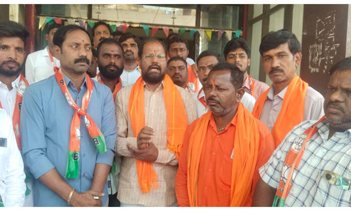 BJP leaders and supporters staging a protest outside RDO office in Nirmal demanding implementation of six guarantees by the Telangana government
