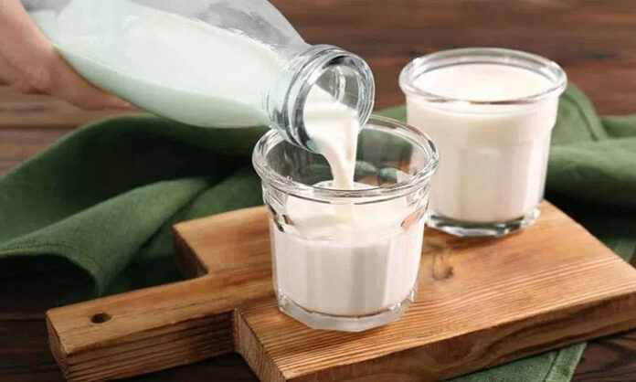 Glass of lukewarm milk on table representing benefits and side effects of drinking milk on an empty stomach