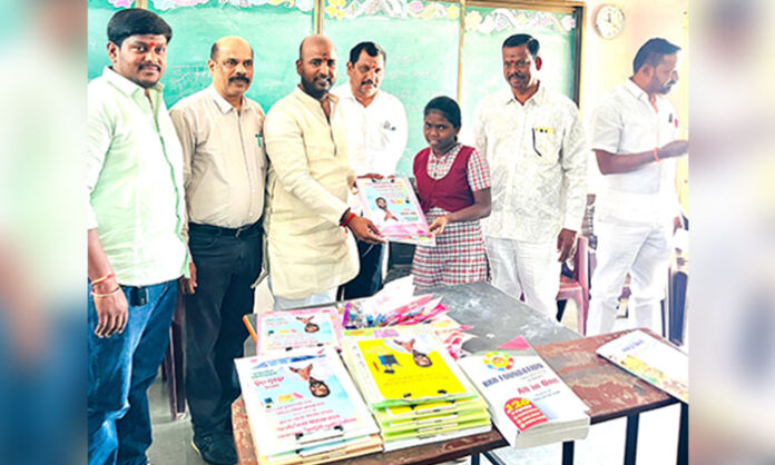 Jeevan Kumar Reddy distributing exam pads and geometry kits to 10th class students at a government school in Abdullapur Met village