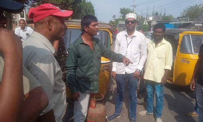 Consumers staging a sit-in protest with empty gas cylinders at Iddam Crossroads on Nirmal Bhainsa highway demanding gas supply