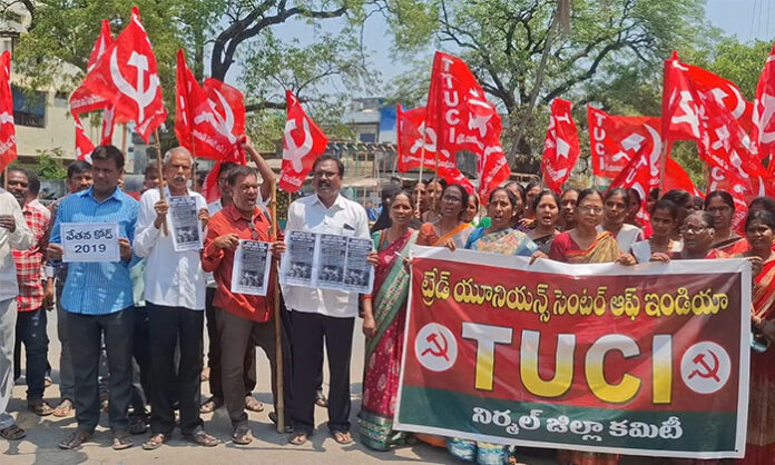 Workers staging a protest outside the RDO office in Nirmal town, burning copies of labour code legislation.