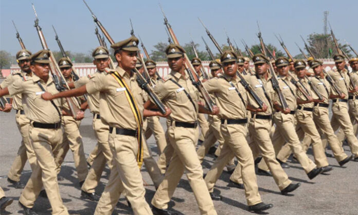 A police officer in khaki uniform standing vigilantly, representing dedication, courage, and service to society.