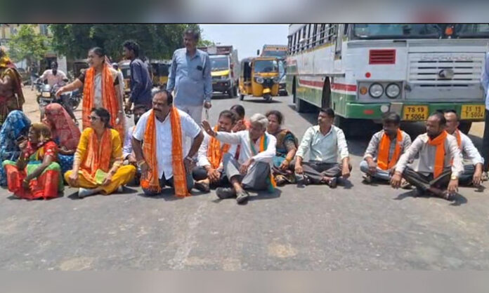 BJP cadres protesting at Kistampet bus stop in Chennur Mandal against Congress over Women Reservation Bill