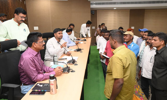 District Collector Kumar Deepak receiving and reviewing Prajavani grievance applications at Integrated District Offices Complex in Naspur