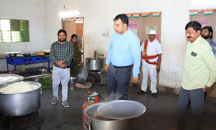 Collector Sandeep Kumar Jha inspecting school kitchen sanitation and food quality at Gurukulam school during welfare week