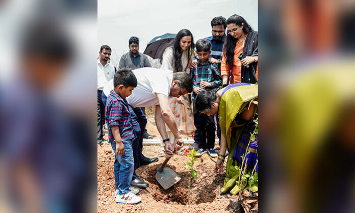 Radhe Group and SankalpTaru Foundation employees planting saplings during Earth Day tree plantation drive at Sriram Nagar community site