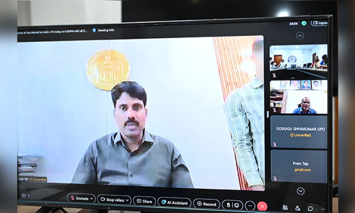 Officials conducting a voter list revision meeting with instructions for BLOs to visit every household and update electoral records during a government review session.