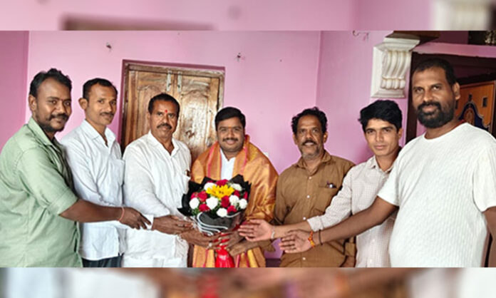 Srikanth Yadav honored with a traditional shawl during a felicitation ceremony in Jawahar Nagar, attended by local Congress leaders and committee members.