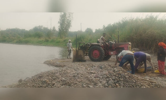 Illegal sand mining operations using heavy machinery and tractors near Siddapur Bridge in Nirmal district, causing environmental damage and public outrage.