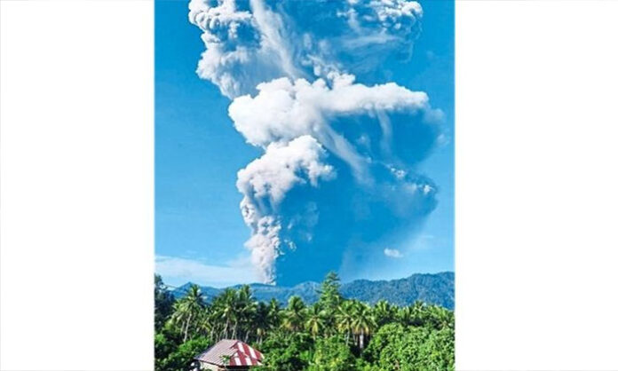 Massive ash cloud rising from Dukono volcano in Indonesia after eruption causing deaths and missing climbers