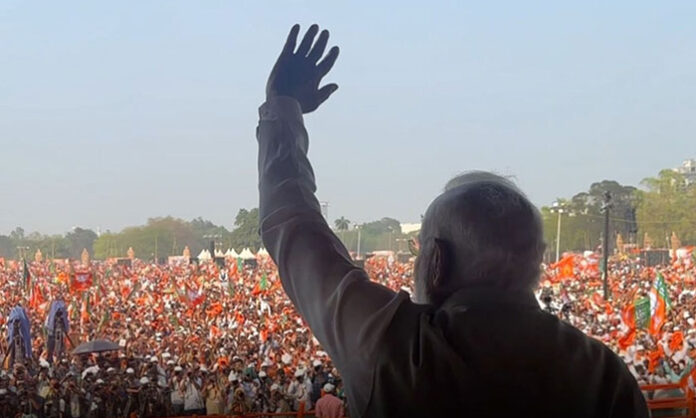 Prime Minister Narendra Modi receiving a thunderous welcome from a massive crowd at Parade Ground during a public meeting in Telangana.