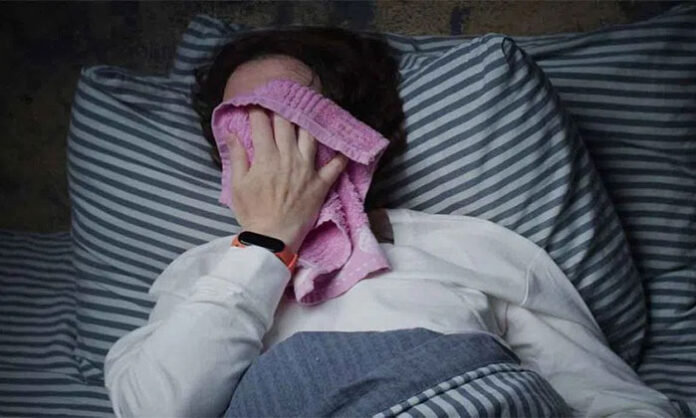 Person experiencing night sweats indicating possible underlying health issues