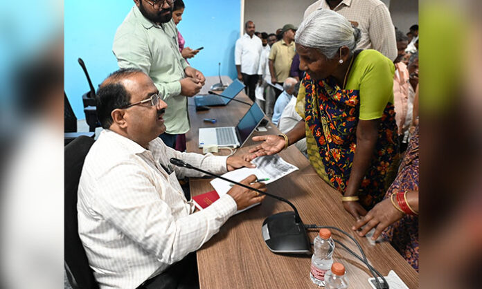 Citizens submitting complaints at Prajavani program in district collector office with officials addressing grievances