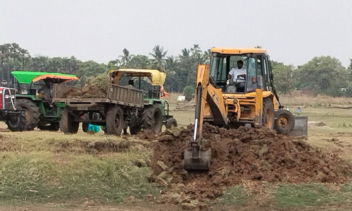 Tractors transporting soil illegally from the Annaram Darga tank area in Parvathagiri Mandal of Warangal district amid allegations of official negligence.