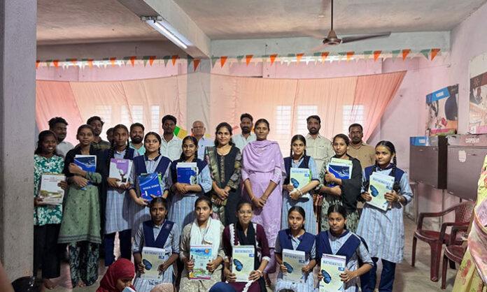 Municipal Chairperson Dava Swathi Ramesh distributing textbooks to students at Bellampalli Minority Residential School