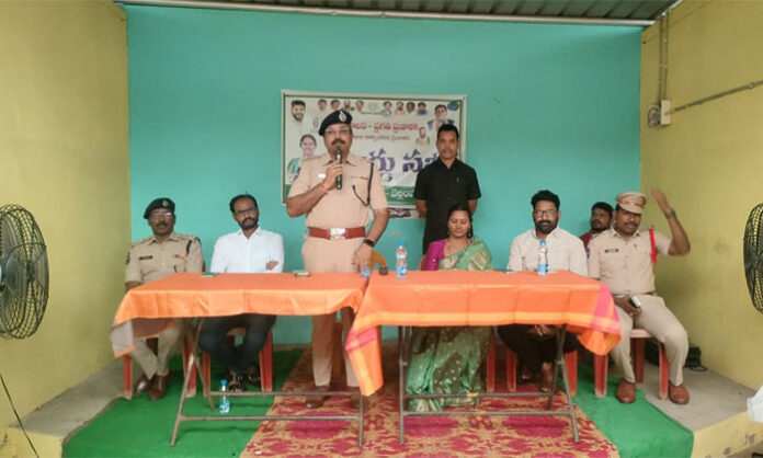 Mancherial DCP A Bhaskar addressing a public awareness program on ganja abuse, cybercrime prevention, and women's safety in Bellampalli.