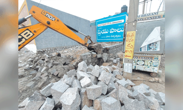 Revenue officials demolish illegal constructions on government land in Jawahar Nagar and warn of strict legal action against encroachers.