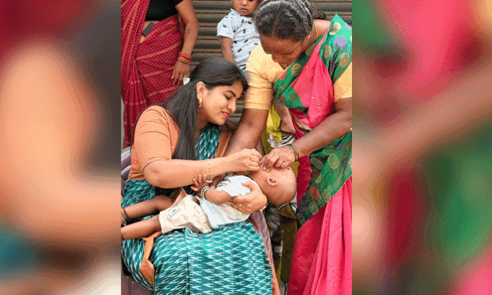 Former Mayor Mekala Kavya administers pulse polio drops to children during the Jawahar Nagar Pulse Polio Program.