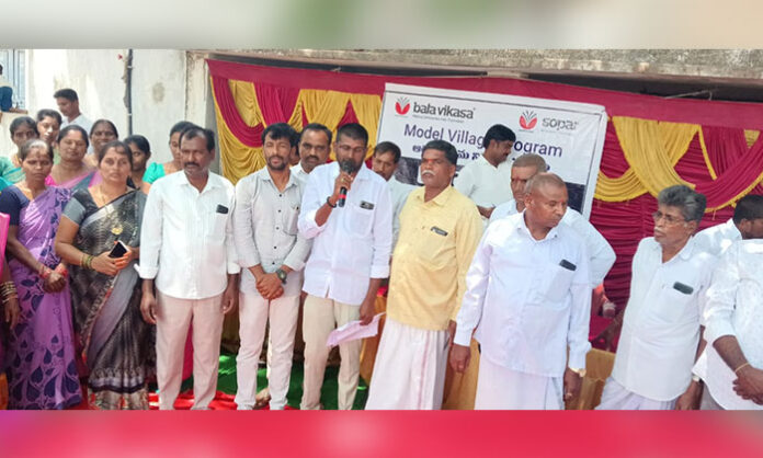 Village Sarpanch Chekkala Parameshwar addressing villagers during a Gram Sabha on model village development in BG Venkatapur.