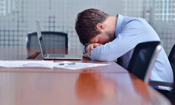 Person feeling sleepy and tired after eating a heavy meal due to digestion-related factors