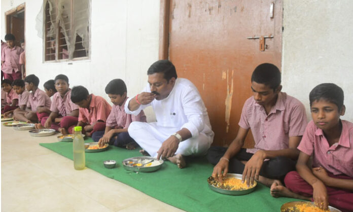 Nirmal MLA Alleti Maheshwar Reddy sharing a meal with students during his surprise visit to the MJP Boys' School.