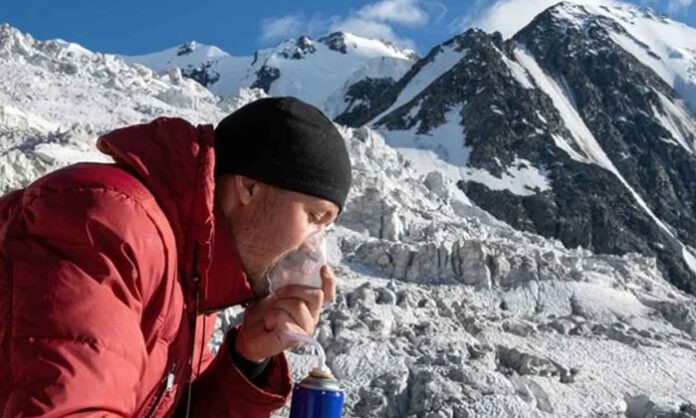A traveler with asthma wearing a jacket in a high-altitude mountain region while taking necessary health precautions.