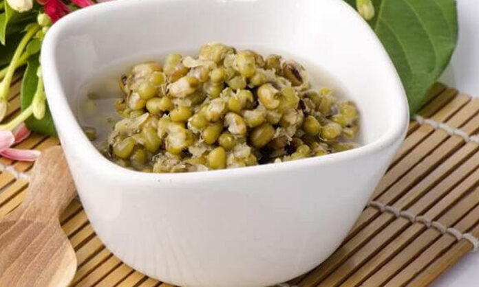 A bowl of boiled green gram served with onions, tomatoes, coriander, and lemon as a healthy, protein-rich meal.