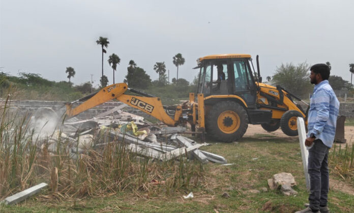 Revenue officials demolishing illegal structures on government land within the FTL limits of Dilawar Khan Cheruvu in Injapur Survey No. 126.