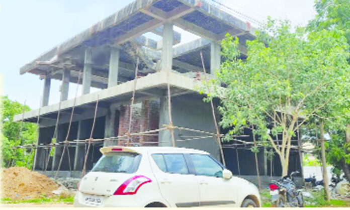 Commercial buildings under construction in Medchal amid allegations of unauthorized development and demands for action by town planning authorities.