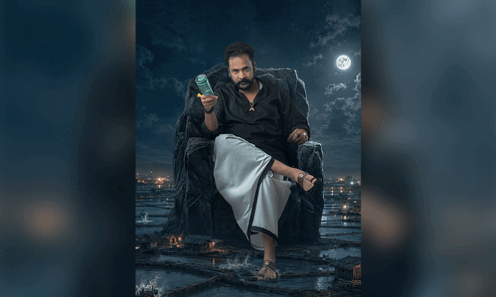 Actor Shivaji as Lailam Babu in the first-look poster of Hailesso, seated on a stone throne in black attire, showcasing his powerful rural character.
