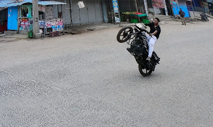 A motorcyclist performing dangerous stunts on a busy road in Mattampally, alarming pedestrians and motorists.