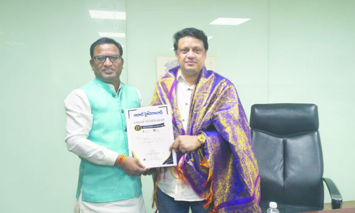 Aadab Hyderabad CMD Satyam Veeramalla presents invitations for the newspaper's 15th anniversary celebration