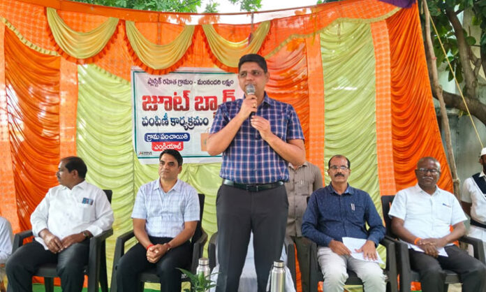 Kamareddy District Collector Ashish Sangwan distributes jute bags during the plastic-free awareness program in Endriyal village.