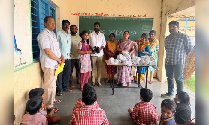 Councilor Lingolla Hanuman Das distributes shoes to students at the Government Primary School in Yadaram village under Aliabad Municipality.