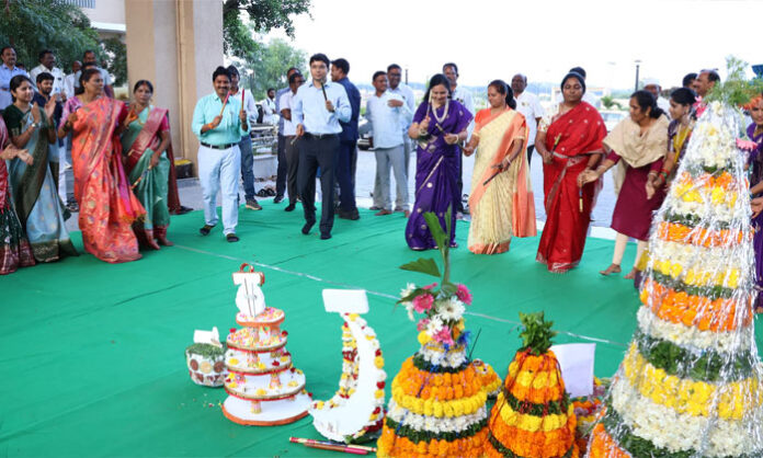 District Collector Bhavesh Mishra and women employees participate in Bathukamma celebrations at the District Collectorate.