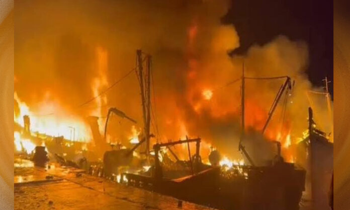 Thick black smoke and flames rise from a conveyor belt under construction near Sea Horse Junction at Visakhapatnam Port.