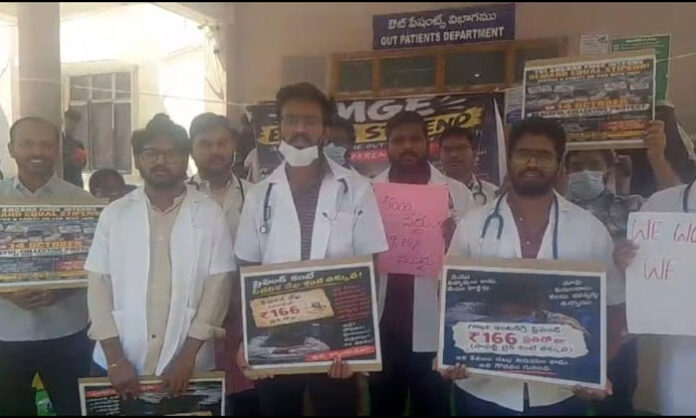 Junior doctors protest outside the government hospital in Nirmal over delayed stipend payments.